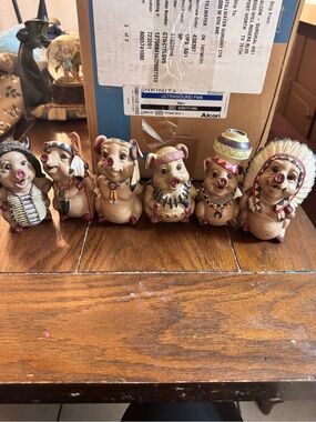 vintage resin figurines of pigs dressed in Native American-themed attire